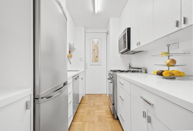 239 E 79th St Unit 9A, New York City, NY 10075 - kitchen featuring stainless steel appliances, white cabinets, and light countertops