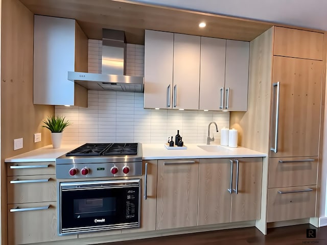 211 E 13th St Unit 6-D, New York City, NY 10003 - kitchen with wall chimney exhaust hood, light countertops, stainless steel gas cooktop, decorative backsplash, and recessed lighting
