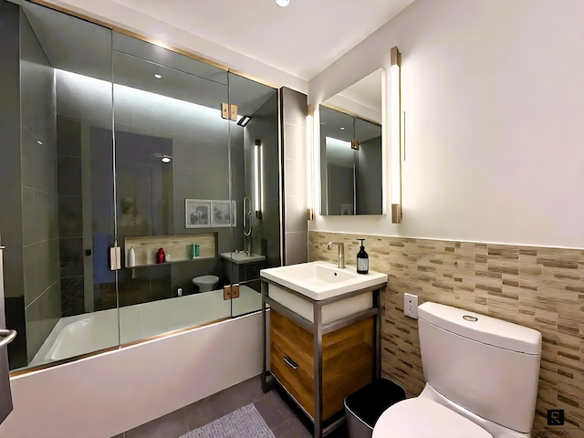 211 E 13th St Unit 6-D, New York City, NY 10003 - full bathroom featuring tile walls, vanity, shower / bath combination with glass door, and tile patterned flooring