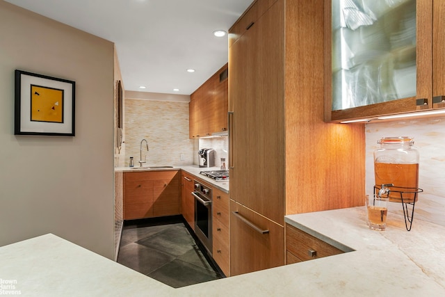 430 W 34th St Unit Lh, New York City, NY 10001 - kitchen with appliances with stainless steel finishes, brown cabinetry, light countertops, tasteful backsplash, and recessed lighting