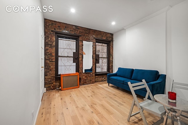 786 9th Ave Unit 2R, New York City, NY 10019 - sitting room featuring brick wall, radiator heating unit, hardwood / wood-style flooring, and recessed lighting