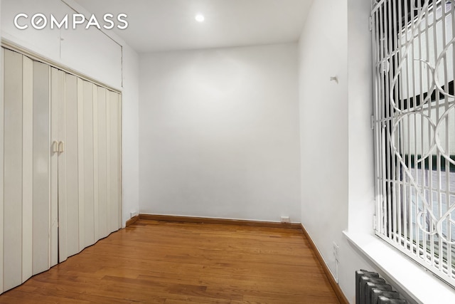 786 9th Ave Unit 2R, New York City, NY 10019 - unfurnished bedroom featuring radiator heating unit and wood finished floors