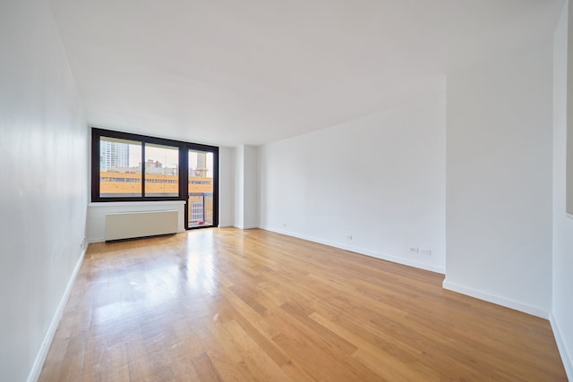 515 E 72nd St Unit 9N, New York City, NY 10021 - empty room featuring radiator and light wood finished floors