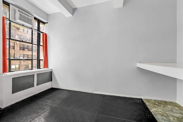 335 W 38th St Unit 11, New York City, NY 10018 - empty room with radiator heating unit, an AC wall unit, and concrete floors
