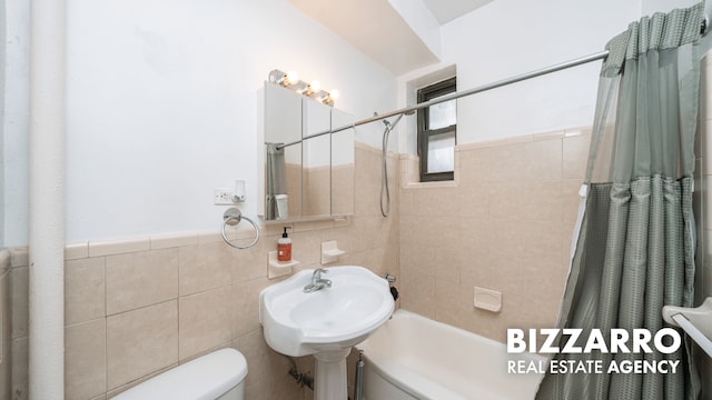 259 Bennett Ave Unit 2F, New York City, NY 10040 - full bathroom with tile walls, shower / bathtub combination with curtain, and a wainscoted wall