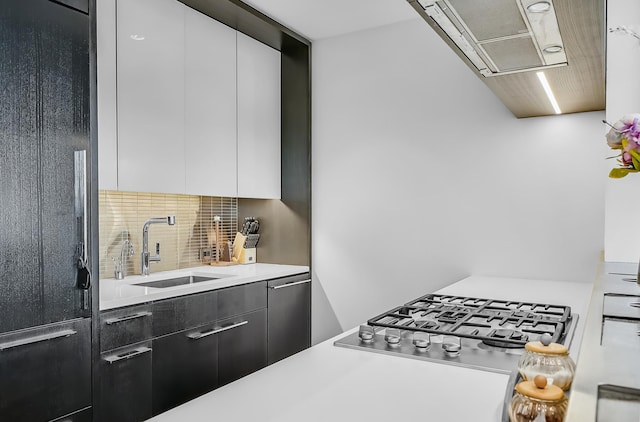 252 S St Unit 73-K, New York City, NY 10002 - kitchen with appliances with stainless steel finishes, tasteful backsplash, light countertops, modern cabinets, and range hood