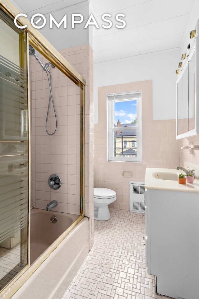 1065 E 39th St, New York City, NY 11210 - full bath featuring vanity, shower / bath combination with glass door, and tile walls