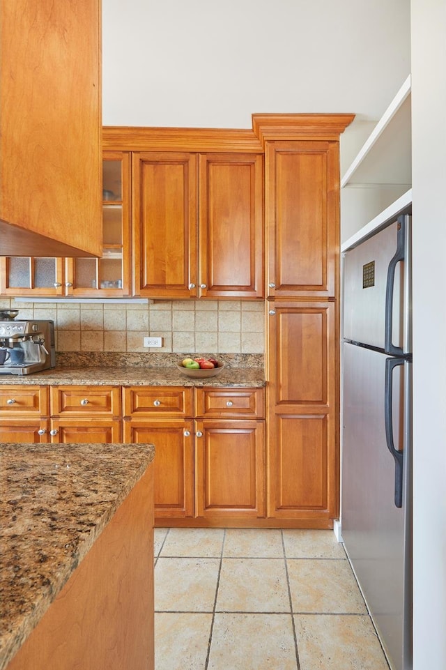 345 E 93rd St Unit 31B, New York City, NY 10128 - kitchen with freestanding refrigerator, brown cabinets, and decorative backsplash