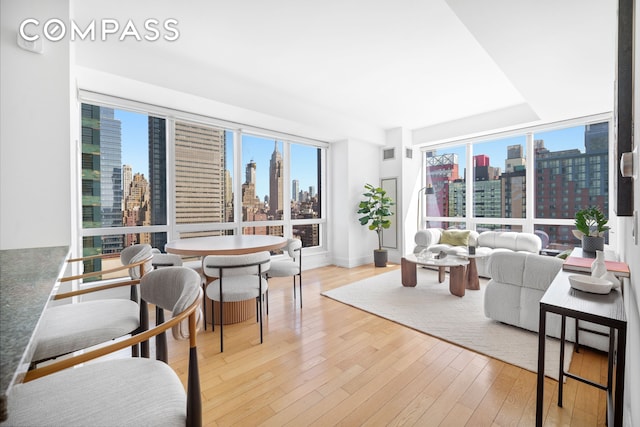 350 W 42nd St Unit 27K, New York City, NY 10036 - living room featuring a view of skyline, light wood-type flooring, and healthy amount of natural light