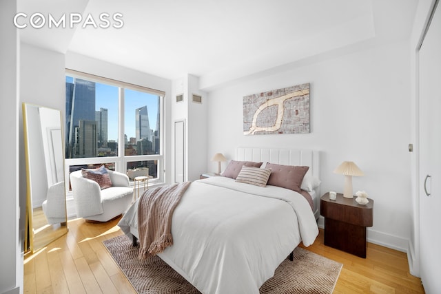350 W 42nd St Unit 27K, New York City, NY 10036 - bedroom with light wood-style flooring and a view of skyline