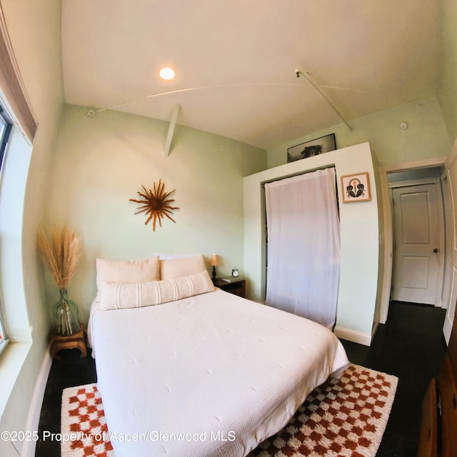 bedroom with baseboards, a closet, and wood finished floors