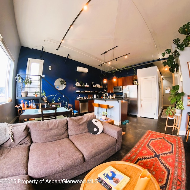 living area with concrete flooring and track lighting