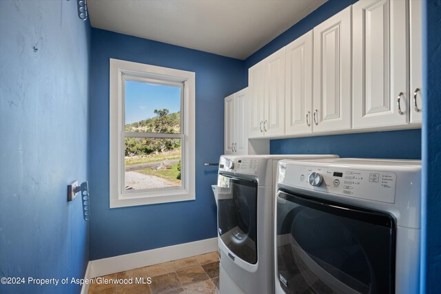 313 Cerise Ranch Rd, Carbondale, CO 81623 - washroom featuring cabinet space, baseboards, washing machine and dryer, and stone finish flooring