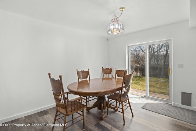 dining room featuring visible vents, baseboards, an inviting chandelier, and wood finished floors
