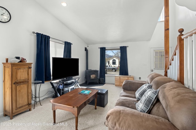living room featuring light carpet, a wood stove, lofted ceiling, and stairs