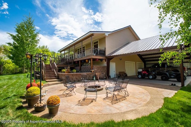 14651 County Road 3, Craig, CO 81625 - rear view of house with stairs, a lawn, a fire pit, metal roof, and a carport