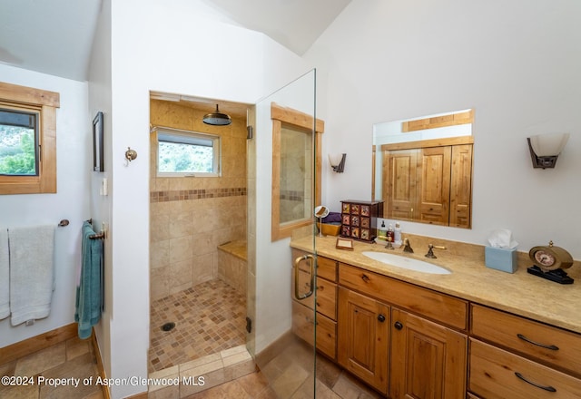 bathroom with tile patterned flooring, vanity, and tiled shower