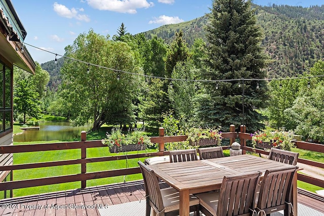 deck with a yard and a water and mountain view