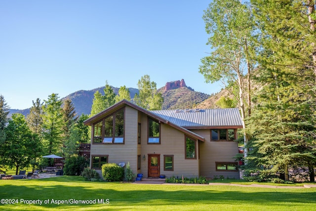 view of front of house with a mountain view and a front lawn