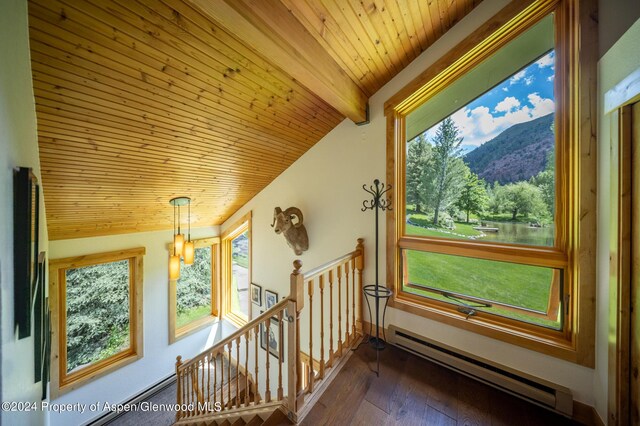 interior space featuring an inviting chandelier, baseboard heating, dark wood-type flooring, and wood ceiling