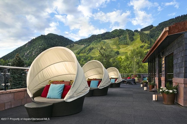view of patio / terrace with a view of trees and a mountain view