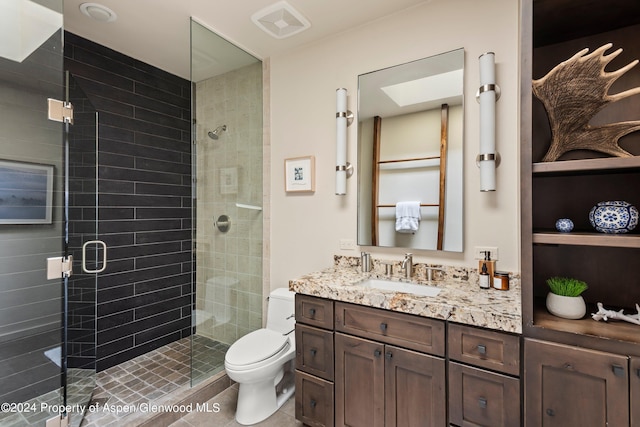 bathroom with vanity, toilet, and a shower with shower door