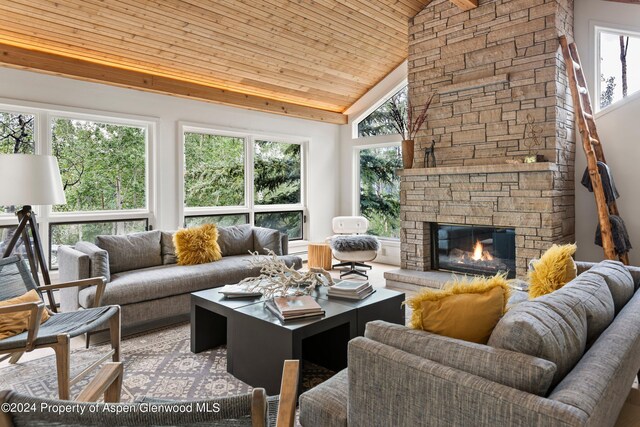 living room featuring a stone fireplace, high vaulted ceiling, and wood ceiling