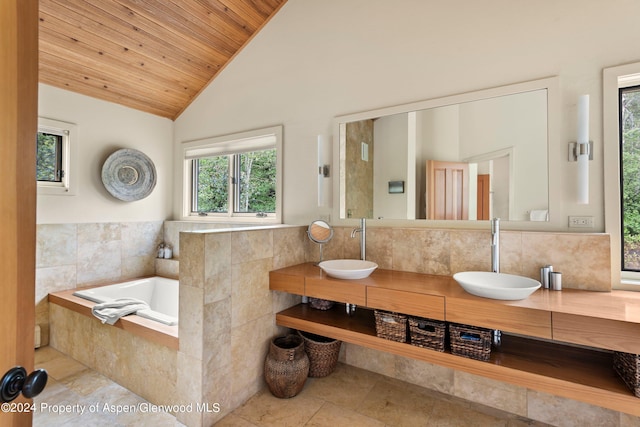 bathroom with tiled bath, vanity, wooden ceiling, and lofted ceiling