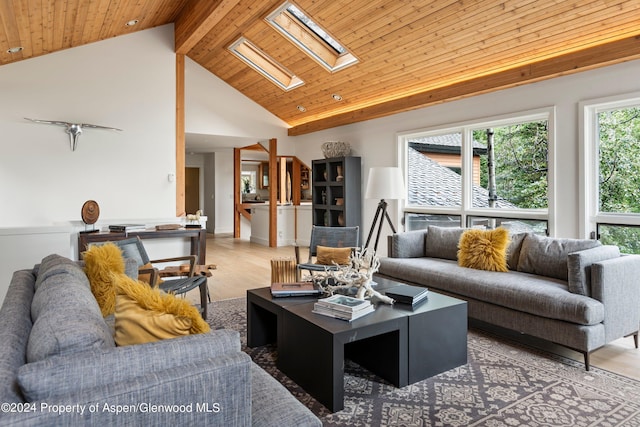 living room with hardwood / wood-style floors, wood ceiling, high vaulted ceiling, and a skylight