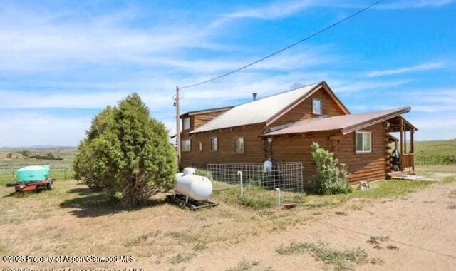 view of property exterior with fence and log siding