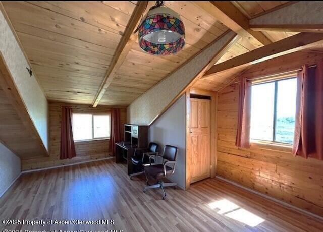 home office with wood finished floors, vaulted ceiling with beams, wood ceiling, and wood walls