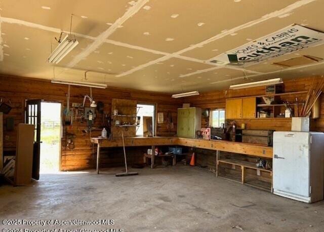 garage featuring wooden walls and a workshop area