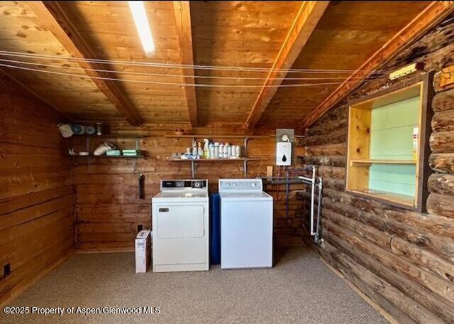 laundry area featuring washer and clothes dryer, wooden walls, wood ceiling, carpet, and laundry area