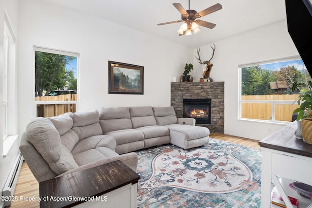24 Lupine Ln, Parachute, CO 81635 - living room featuring a baseboard heating unit, ceiling fan, wood finished floors, and a fireplace