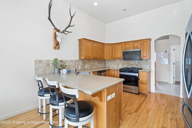 24 Lupine Ln, Parachute, CO 81635 - kitchen featuring stainless steel appliances, a sink, light countertops, arched walkways, and tasteful backsplash