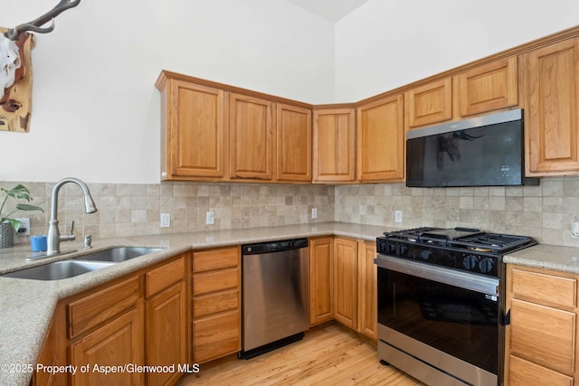 24 Lupine Ln, Parachute, CO 81635 - kitchen featuring stainless steel appliances, a sink, light wood-type flooring, tasteful backsplash, and light stone countertops