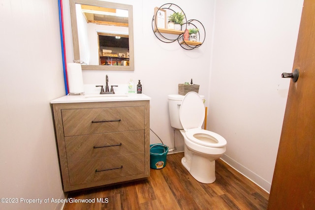 bathroom featuring hardwood / wood-style floors, vanity, and toilet