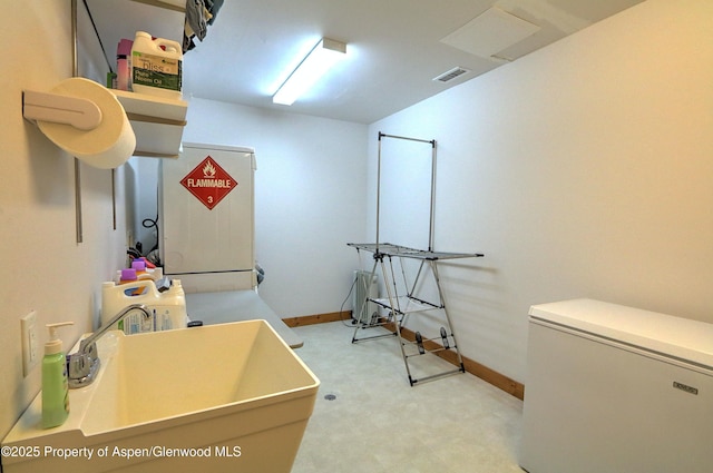 interior space with baseboards, a sink, and tile patterned floors