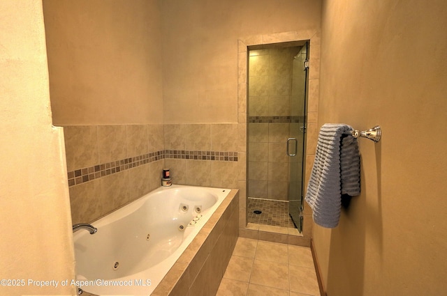 bathroom featuring a tub with jets, tile patterned floors, and a stall shower