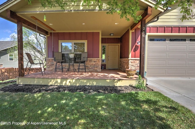 exterior space featuring a lawn, board and batten siding, an attached garage, and stone siding
