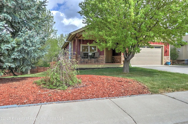 view of front facade with a porch, driveway, fence, an attached garage, and stone siding