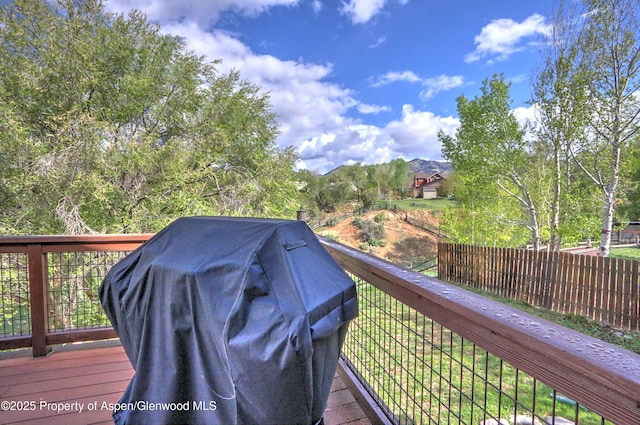 wooden deck with fence and area for grilling