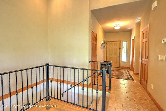 hallway featuring baseboards and an upstairs landing