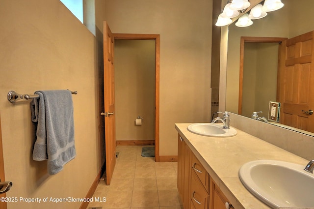 bathroom featuring tile patterned flooring, a sink, a notable chandelier, and double vanity