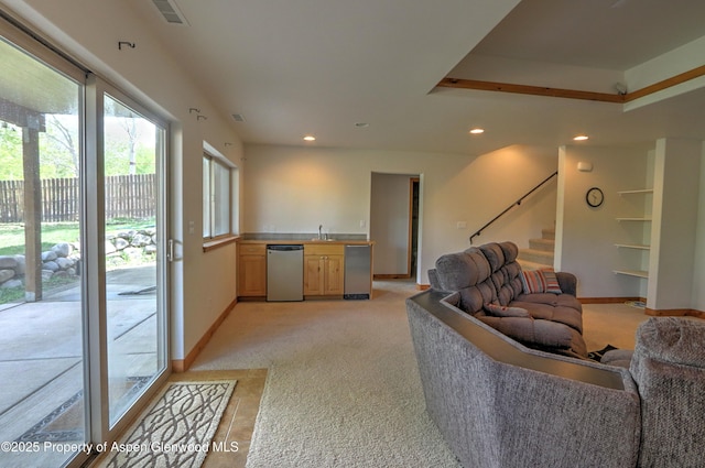 living room with recessed lighting, baseboards, light carpet, and stairway
