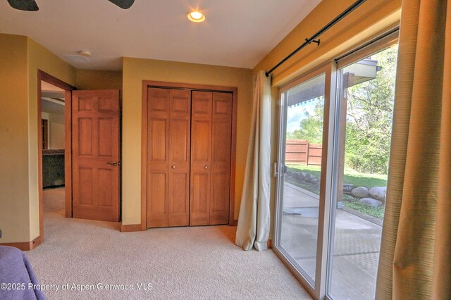 unfurnished bedroom featuring access to outside, light colored carpet, recessed lighting, baseboards, and a closet