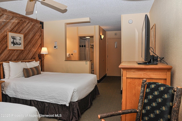 bedroom featuring ceiling fan, wood walls, a textured ceiling, and carpet