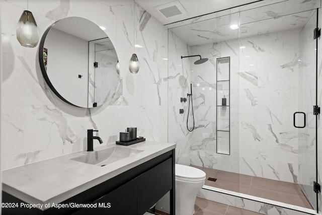 bathroom with vanity, toilet, walk in shower, and tile walls