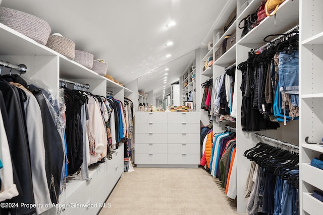 walk in closet featuring light colored carpet