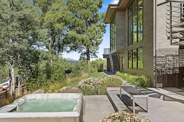 view of patio featuring a mountain view and a hot tub